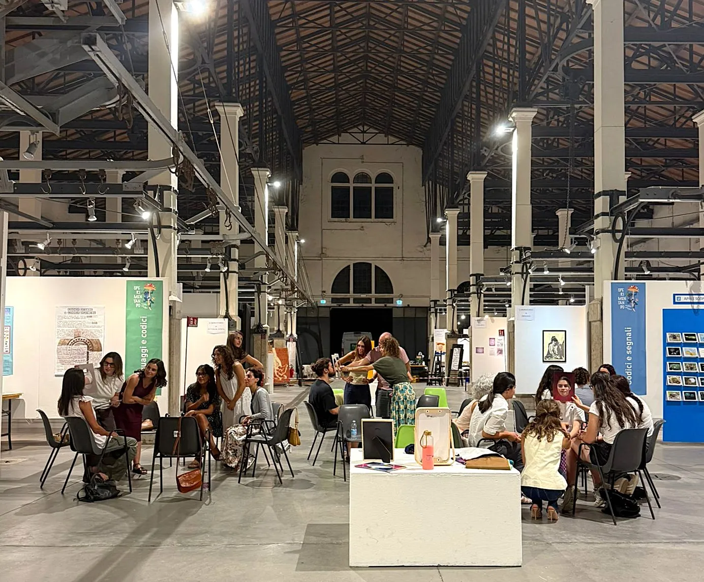 Persone partecipano a un evento in uno spazio espositivo industriale