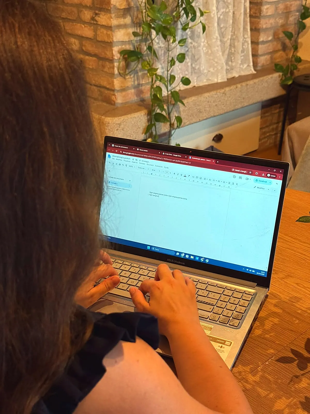 Valentina Alberti al computer, di spalle, mentre scrive il copy per un progetto cliente