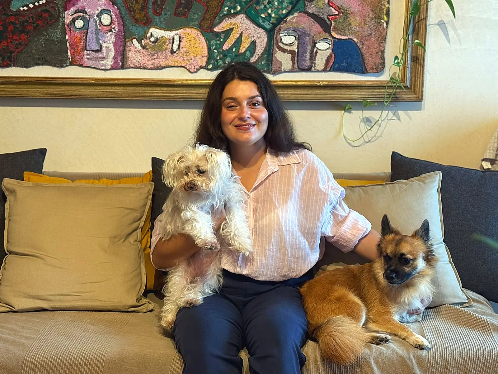 Valentina Alberti sorridente sul divano di casa con i suoi due cani